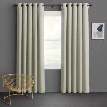 Grommet-top pale sage curtains, floor-length with deep pleats, hung on a metal rod and parted slightly, filtering soft daylight over a gray-walled room with gold wire chair and abstract art.