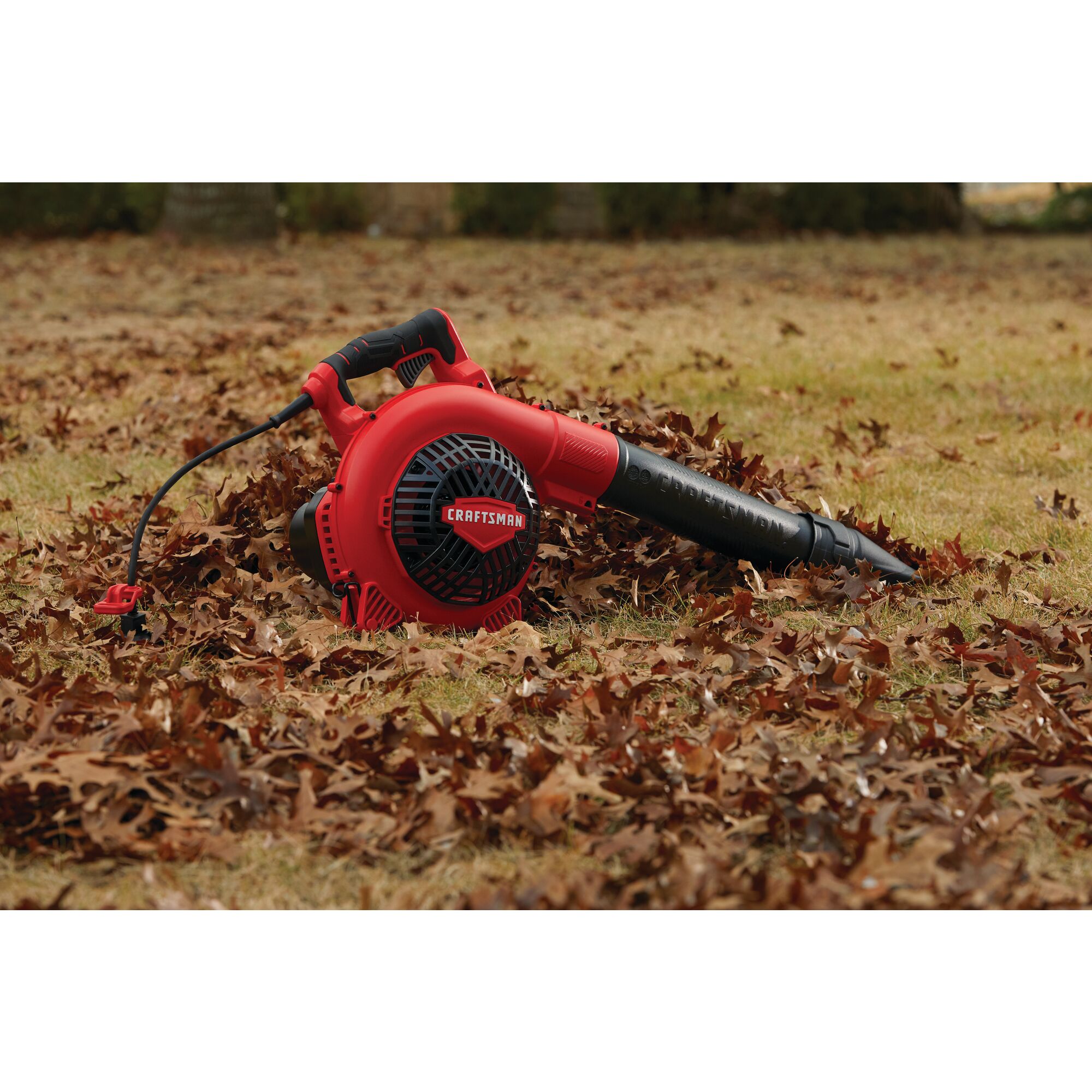 12 amp corded handheld jobsite blower being used in a lawn.