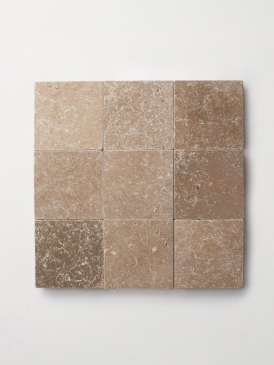 a square of beige travertine tile on a white background.