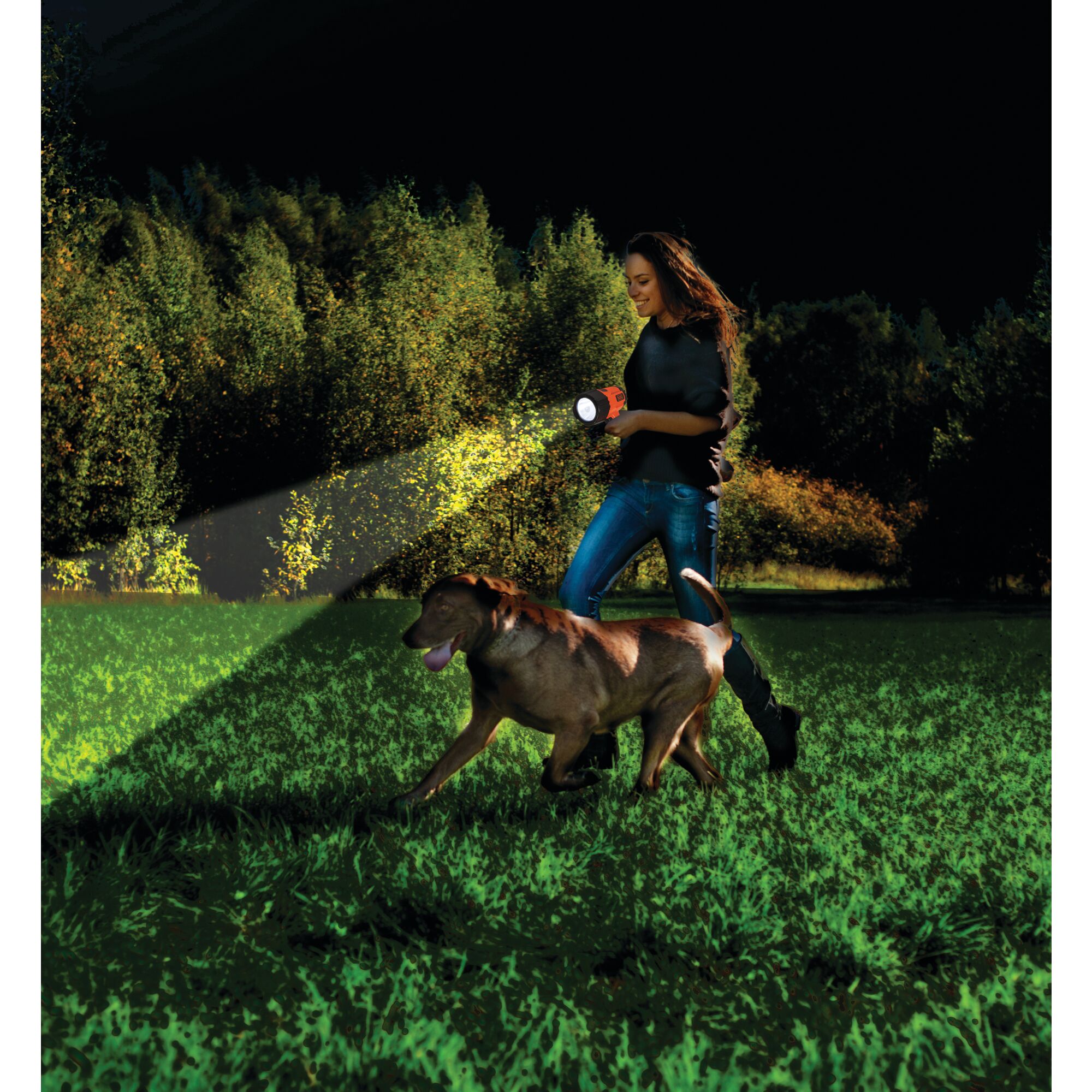 Woman using BLACK+DECKER spotlight at night with dog next to her