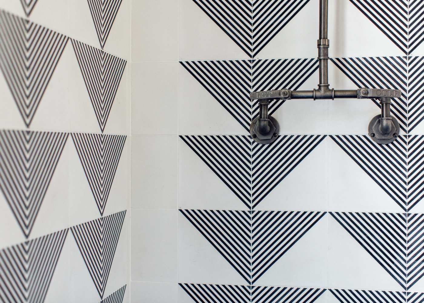 a bathroom with a black and white striped tile shower.