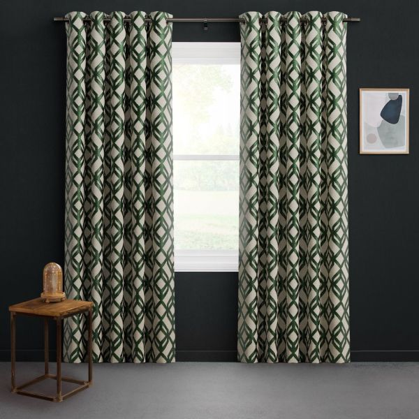 Grommet-top cream curtains with dark green interlocking geometric pattern, hung on a metal rod, parted to frame a daylight window; dark-walled room with a wooden side table and abstract art.