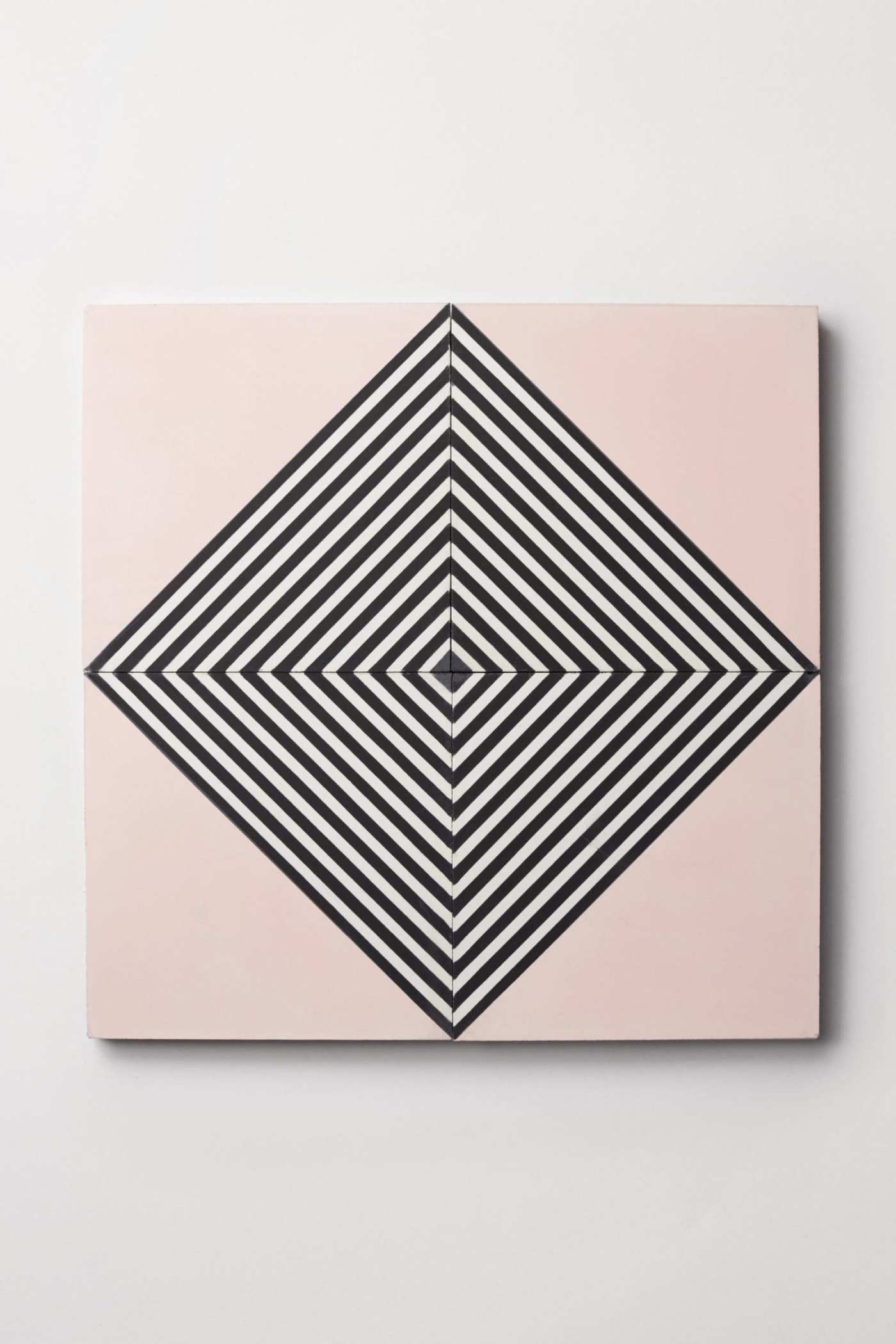 four pink tiles forming a black and white diamond pattern.