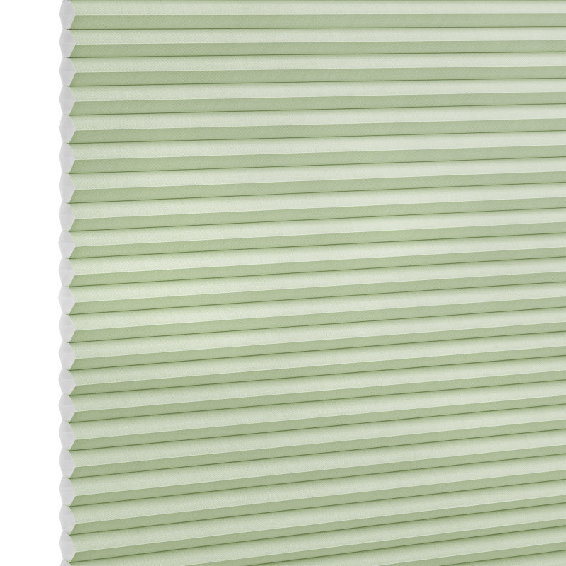 Pale green honeycomb (cellular) blind with visible hexagonal cells at left, fully lowered and closed, softly filtering light; studio-lit product shot on a white background.