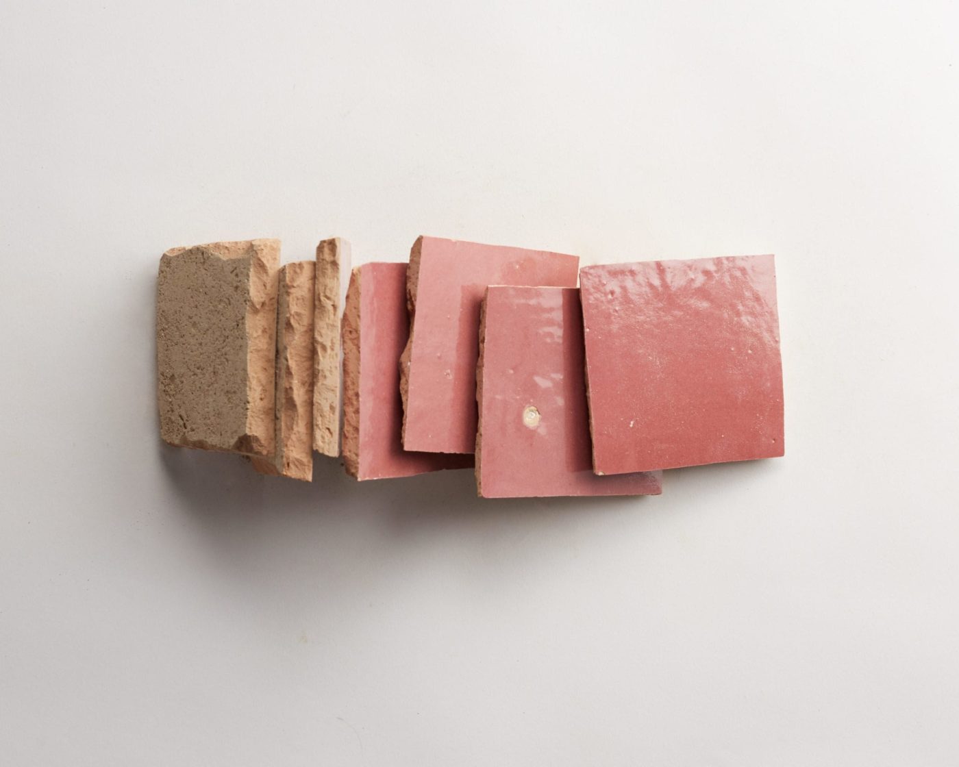 a stack of pink tiles on a white surface.