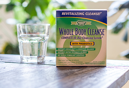 Box of Nature's Way Whole Body Cleanse on brown table next to glass of water.