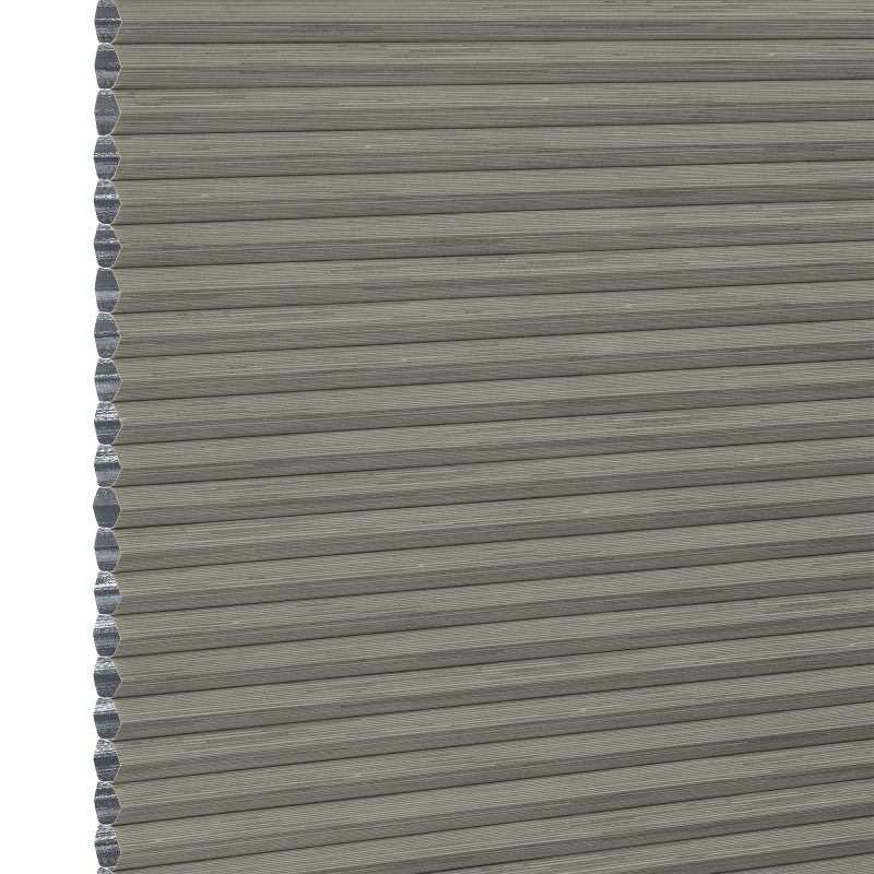 Grey cellular (honeycomb) pleated blind, fully lowered with visible hexagonal side cells, blocking light; close-up view showing textured fabric and narrow horizontal pleats, plain neutral background.