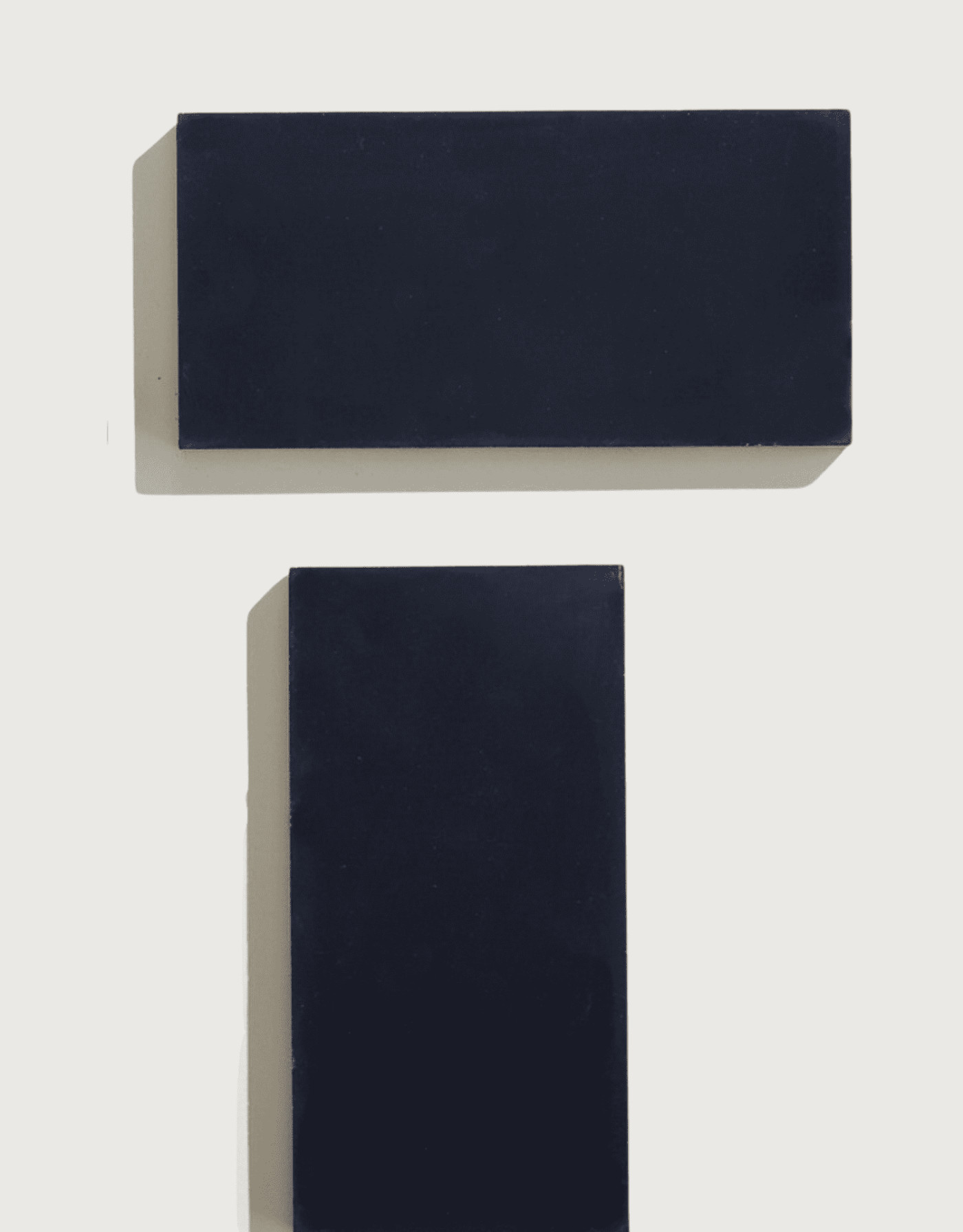 a pair of black rectangle tiles on a white surface.