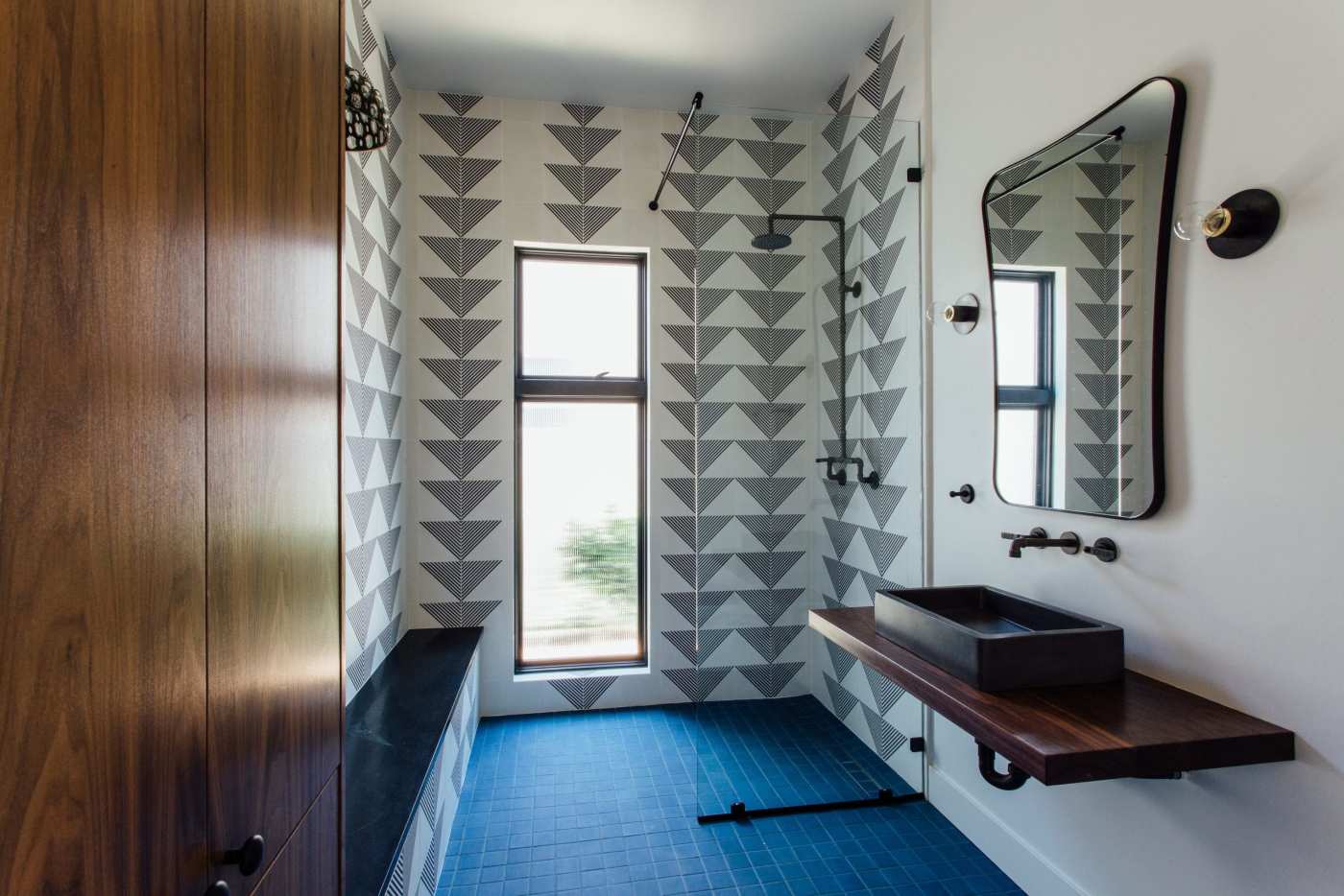 a bathroom with a blue tile floor and walls with geometric patterns.