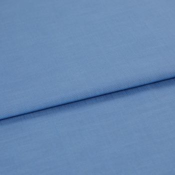 Blue woven fabric, folded with a horizontal overlap and visible fine weave; laid flat on a neutral surface under soft, even lighting in a close-up studio view.