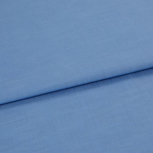 Blue woven fabric, folded with a horizontal overlap and visible fine weave; laid flat on a neutral surface under soft, even lighting in a close-up studio view.