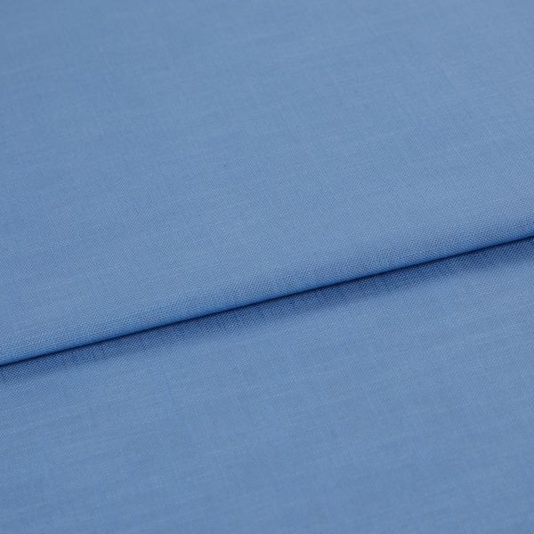 Blue woven fabric, folded with a horizontal overlap and visible fine weave; laid flat on a neutral surface under soft, even lighting in a close-up studio view.