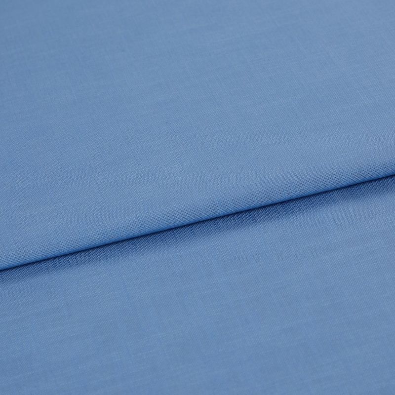 Blue woven fabric, folded with a horizontal overlap and visible fine weave; laid flat on a neutral surface under soft, even lighting in a close-up studio view.