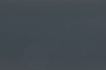 Dark gray-blue matte surface filling the frame, with faint vertical scratches; unadorned and featureless, low ambient light, ambiguous interior or exterior setting.