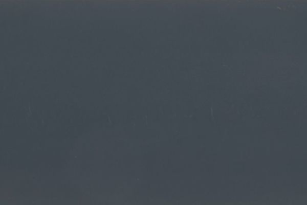 Dark gray-blue matte surface filling the frame, with faint vertical scratches; unadorned and featureless, low ambient light, ambiguous interior or exterior setting.
