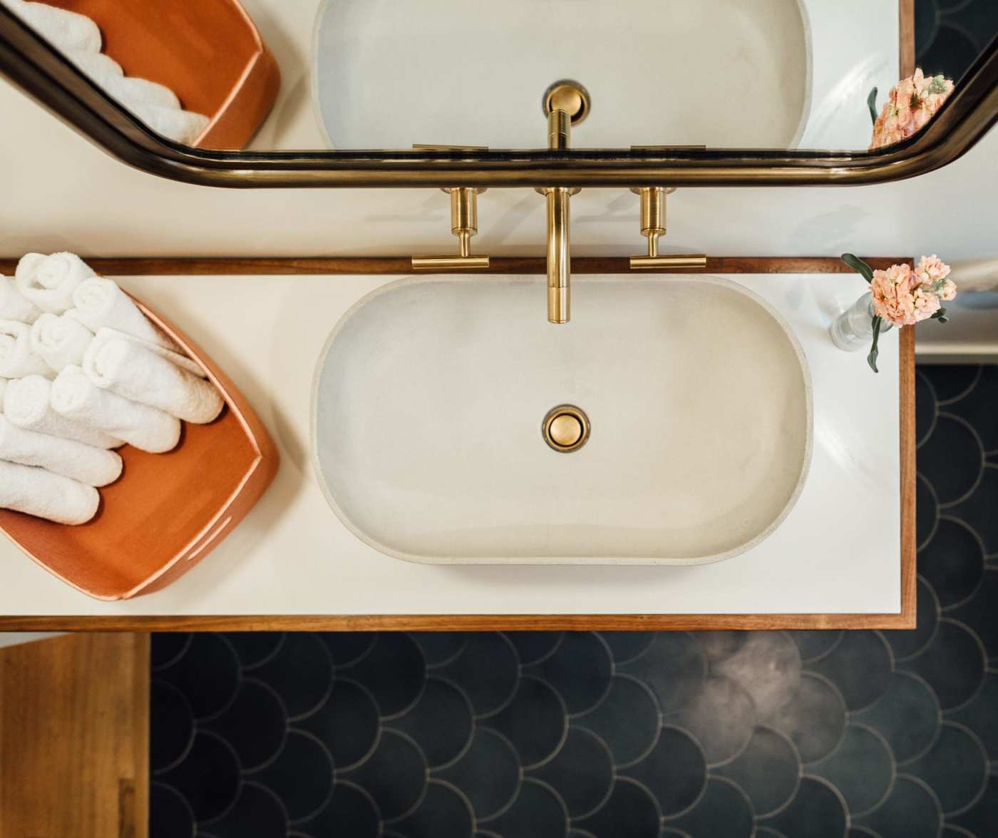 a bathroom with a sink, mirror and towels.