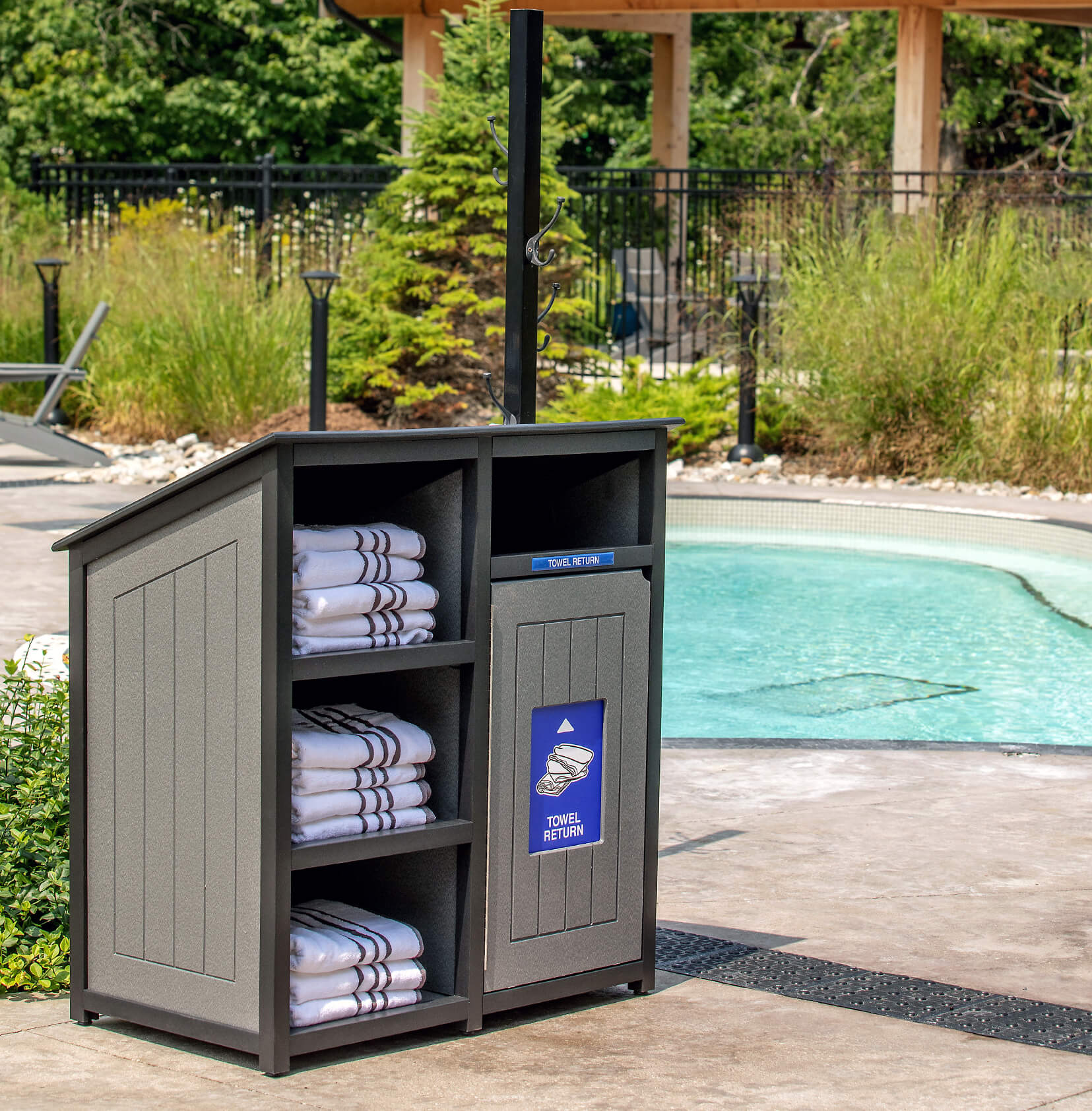 grey and black towel station and receptacle sitting beside a pool