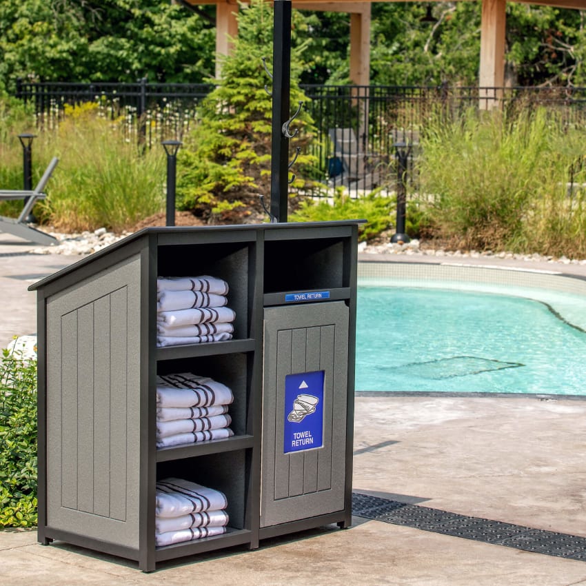 grey and black towel station and receptacle sitting beside a pool