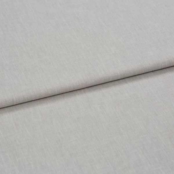 Light gray linen-like fabric folded horizontally, creating a soft crease; close-up shows fine woven texture under even neutral lighting, appearing as a fabric sample or upholstery material on a flat surface.