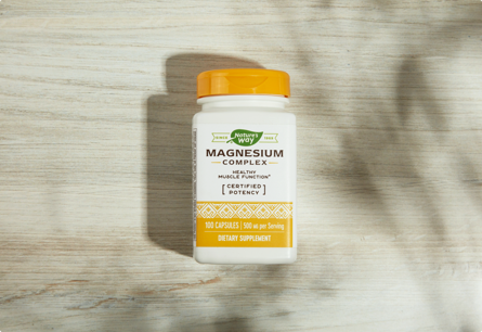 A bottle of Magnesium Complex laying on a table.