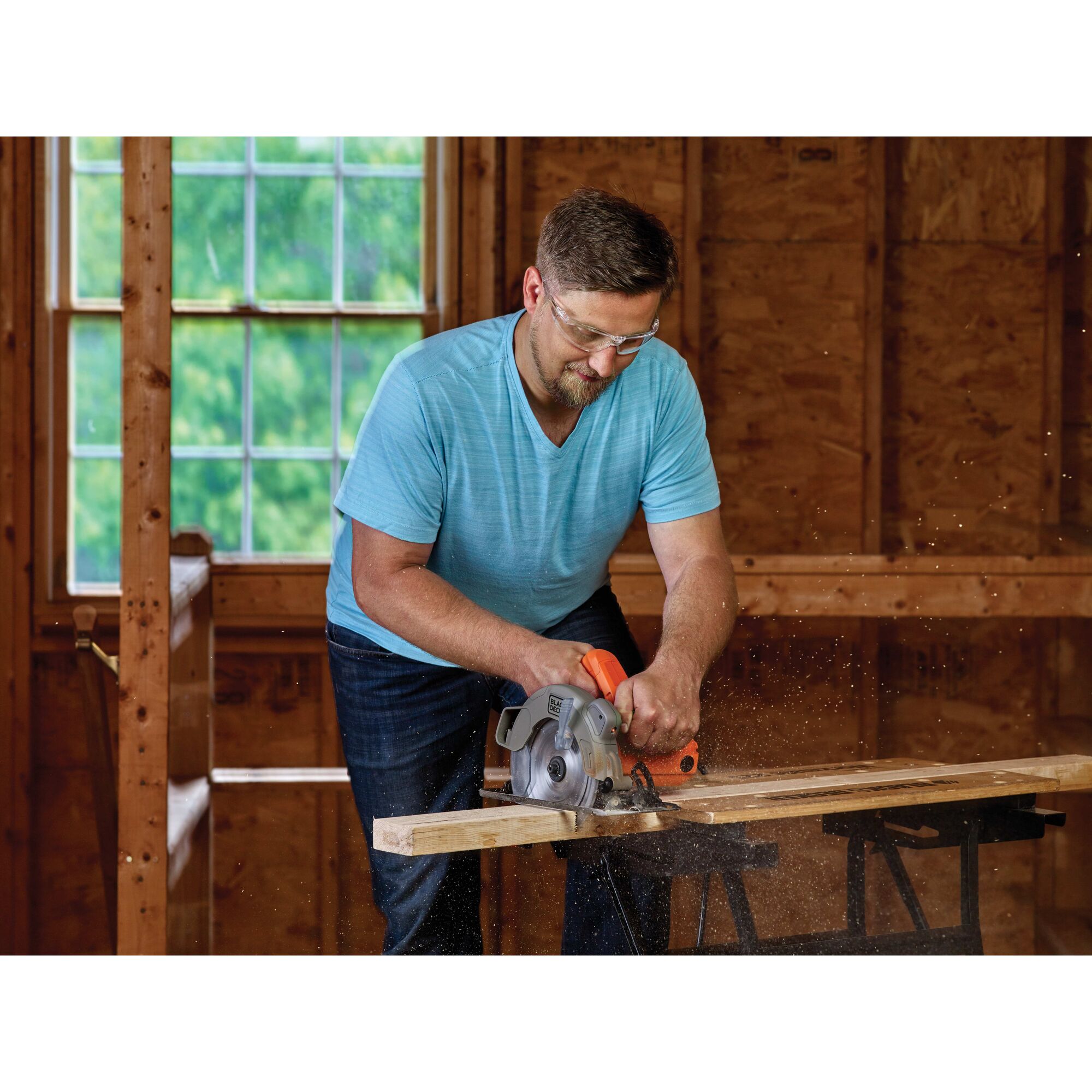 Person using black and decker 7-1/4-Inch Circular Saw With Laser, 13-Amp to cut wooden material