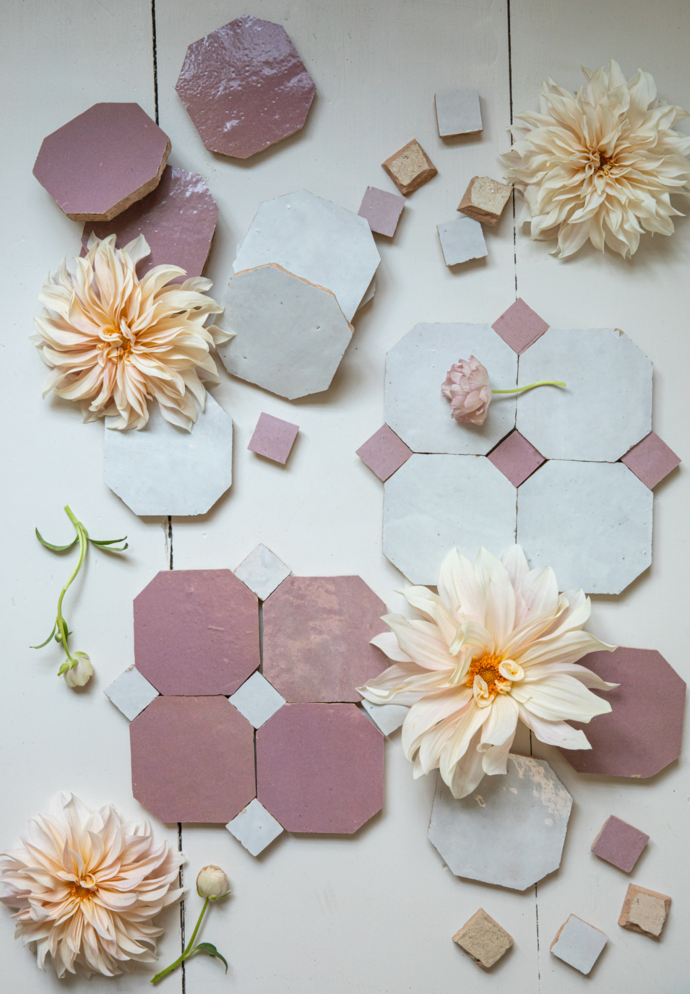 pink and white tiles and flowers on a white surface.