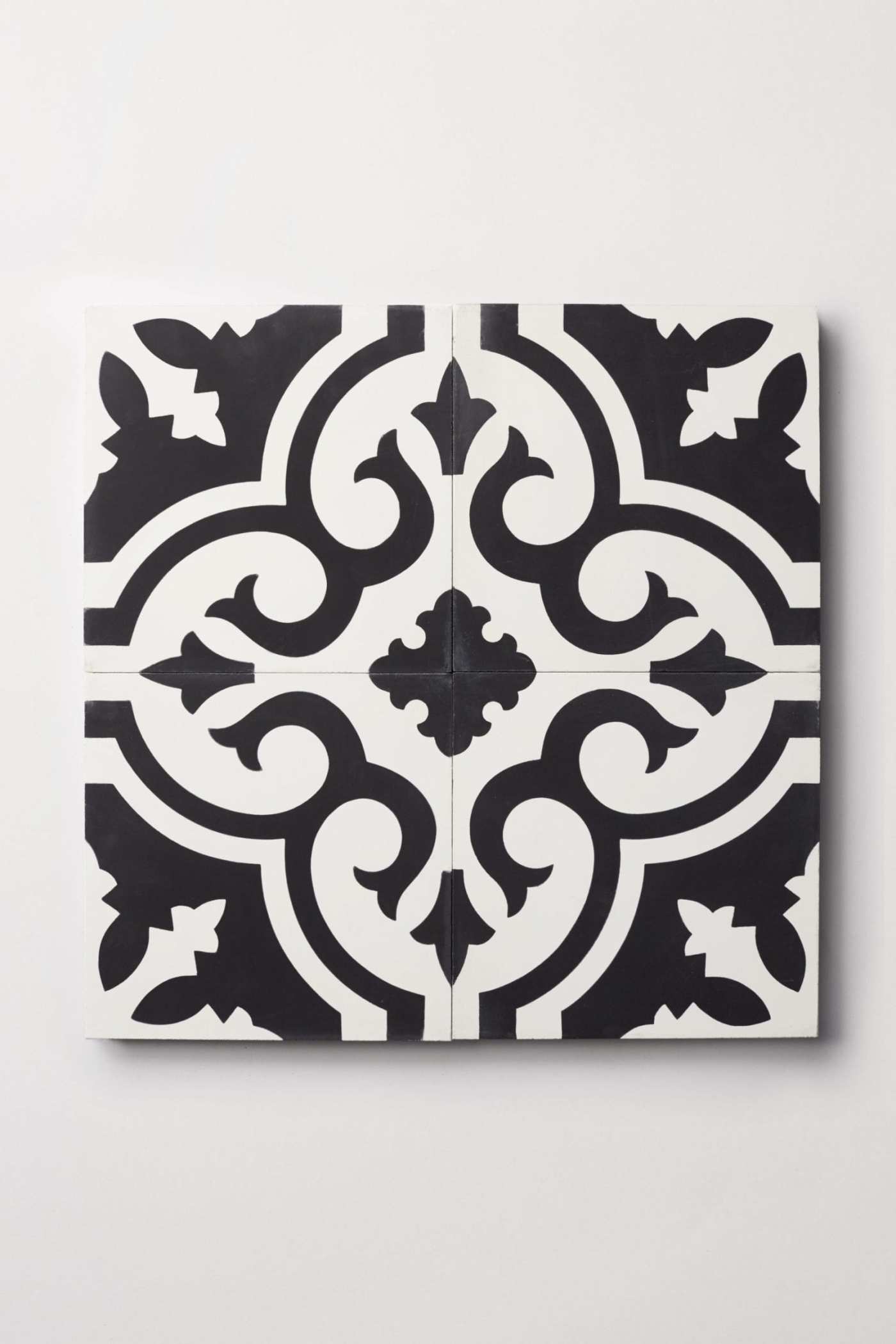 four black and white tiles with ornate designs.