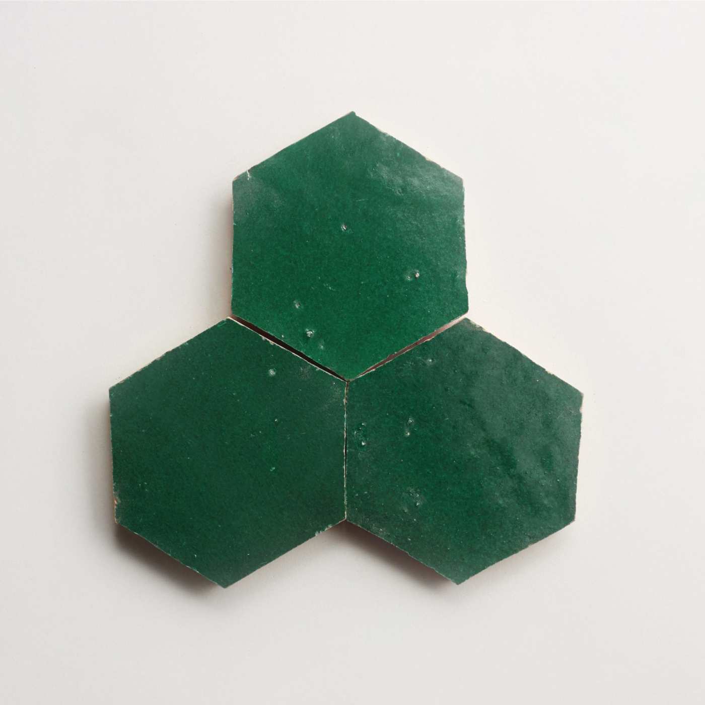 three green hexagon tiles on a white surface.