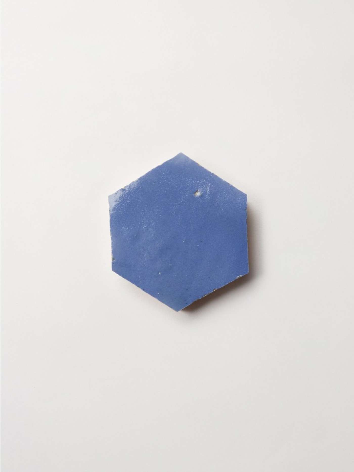 a blue hexagonal tile on a white surface.