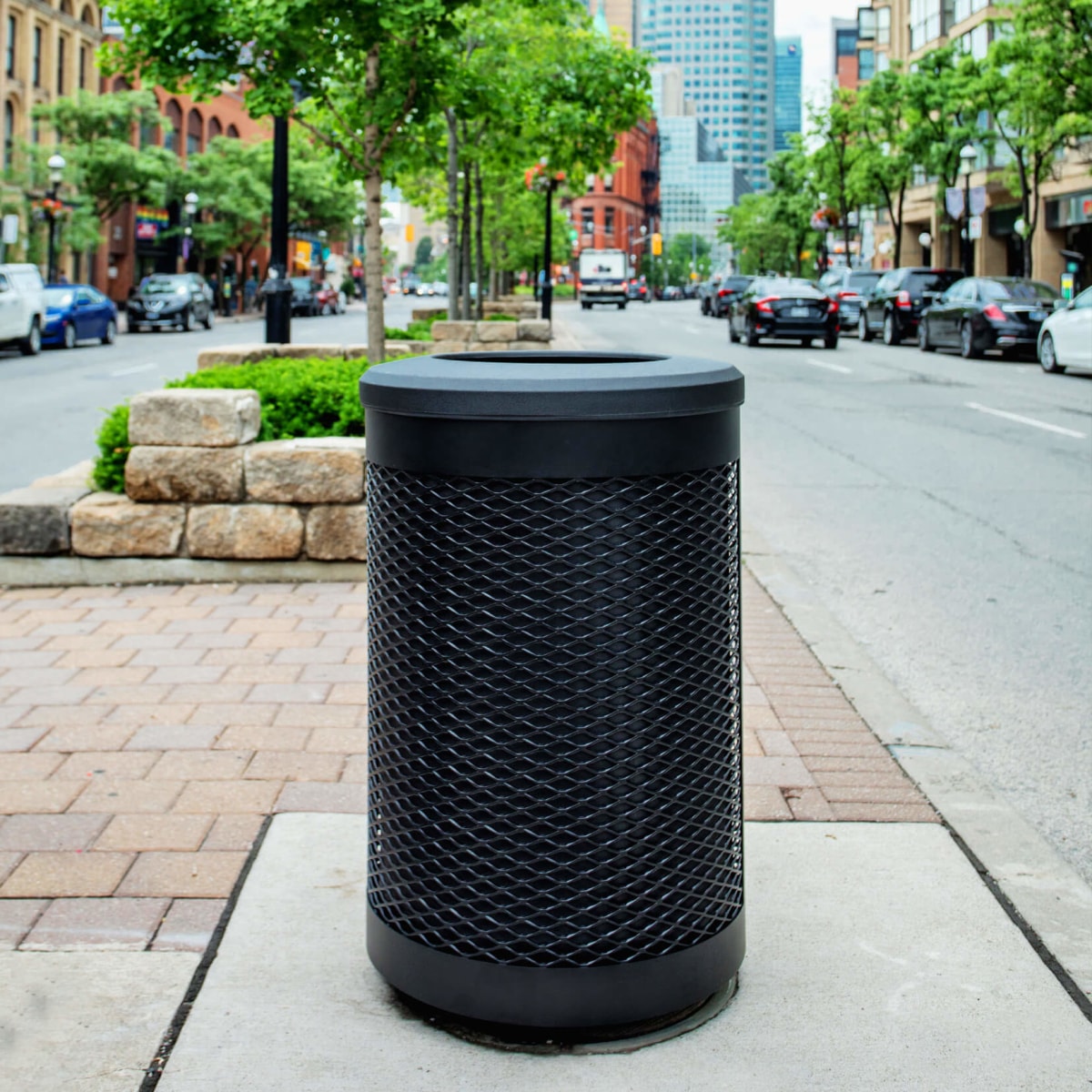 durable steel and plastic outdoor recycling and waste container on a city street with cars parked on both sides