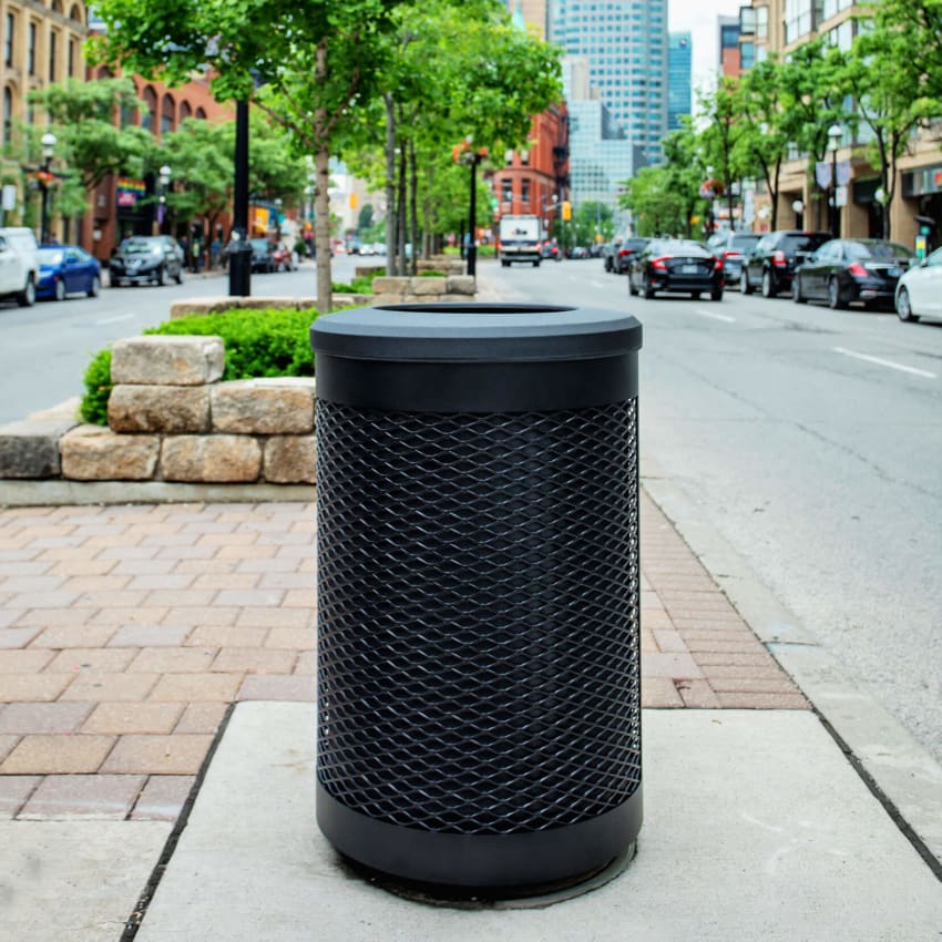 durable steel and plastic outdoor recycling and waste container on a city street with cars parked on both sides