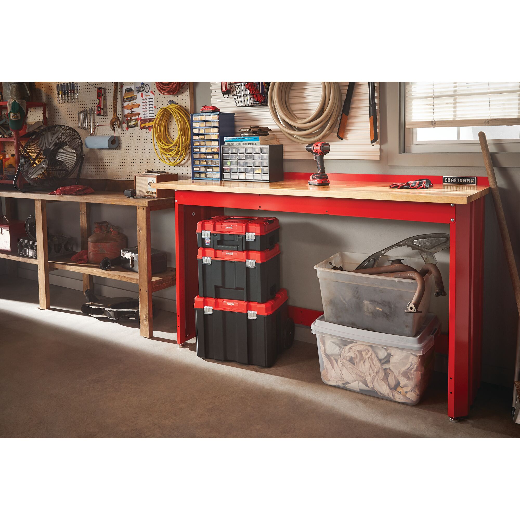 6 foot wide Workbench with Butcher Block Top having tools and storage boxes on its top placed on ground in a garage workshop.