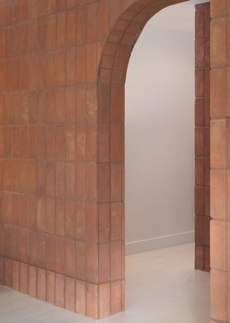 a hallway with a red tiled wall.