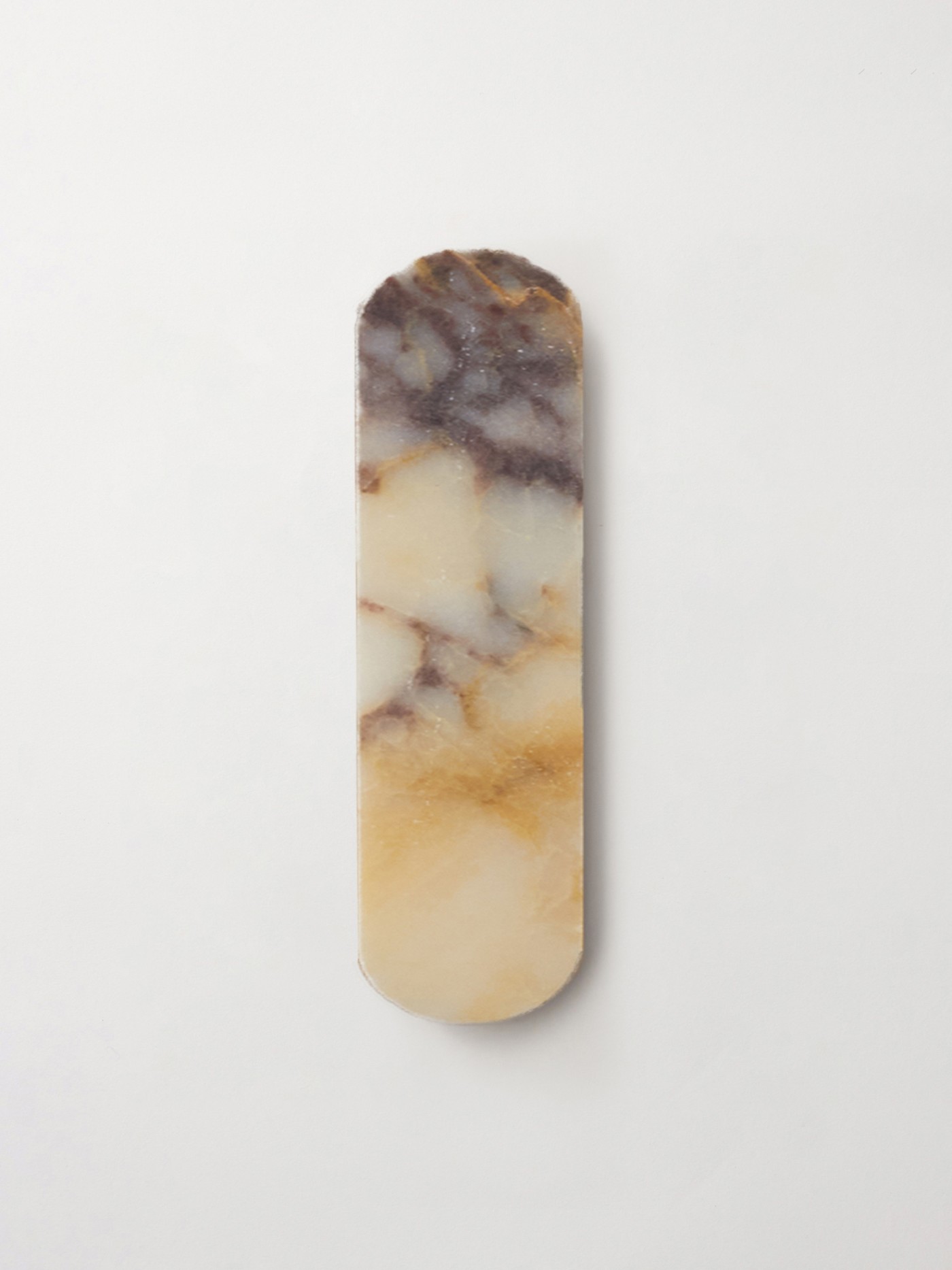 an oval piece of marble tile on a white surface.