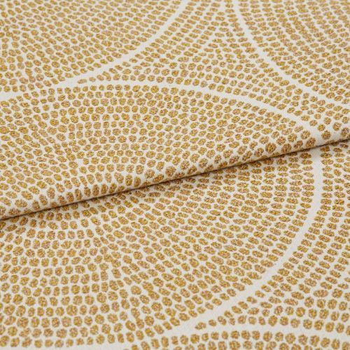 Cream woven fabric with raised golden-dot concentric pattern, folded and slightly overlapped, shown in a close-up with soft, even lighting and shallow depth of field.