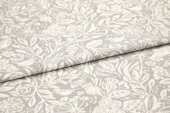 Folded beige cotton-linen fabric with white botanical print, overlapping fold across center; pattern of leaves, flowers and birds; close-up on a flat surface with soft, even lighting.