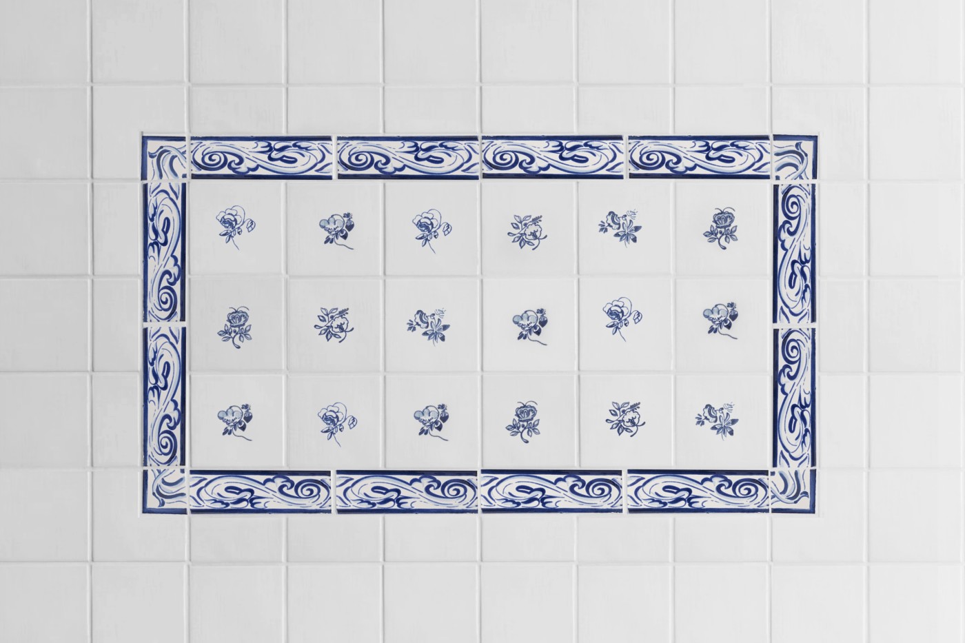 a blue and white tiled wall with flowers on it.