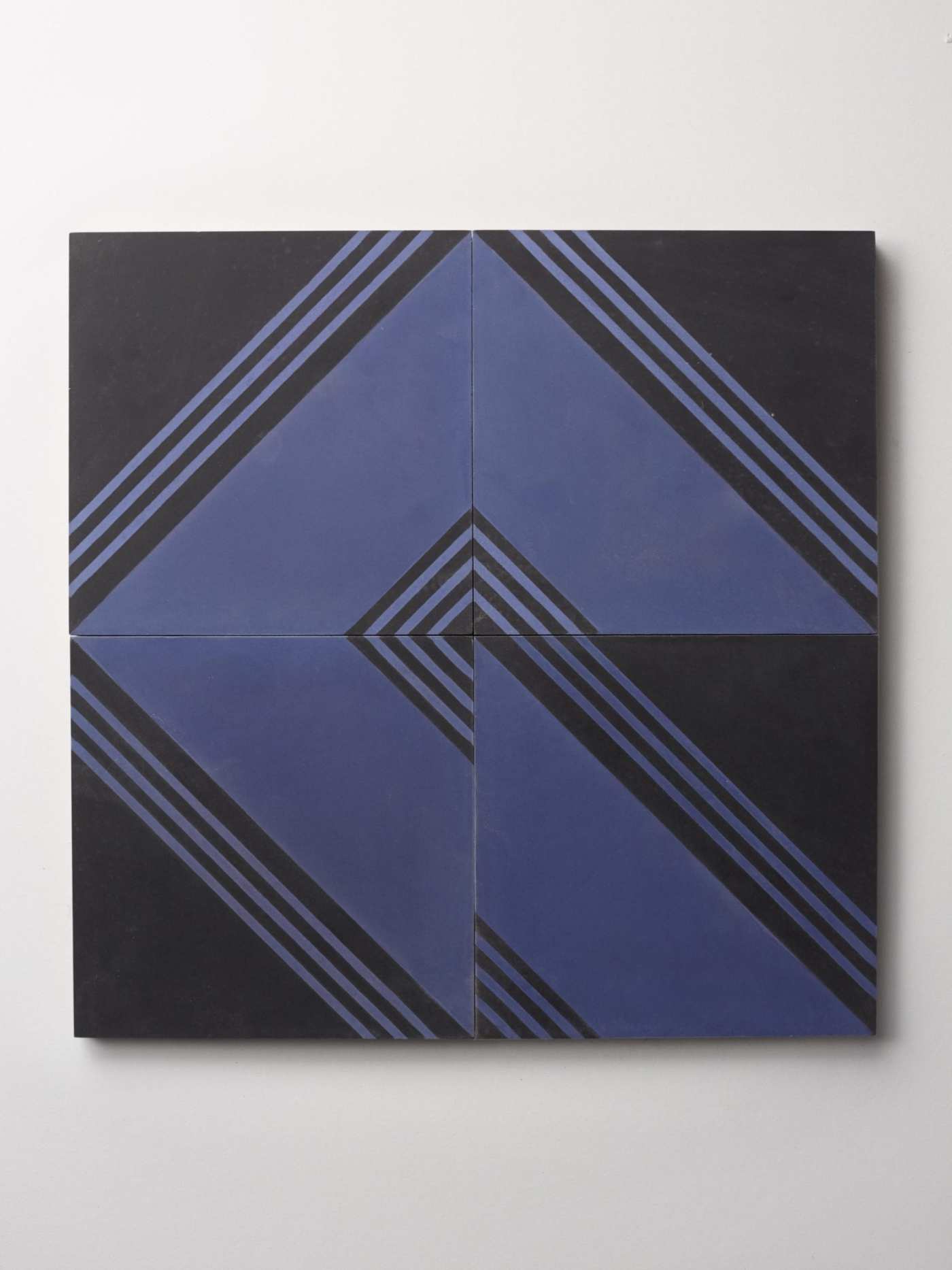 four blue and black tiles with striped designs on a white background.