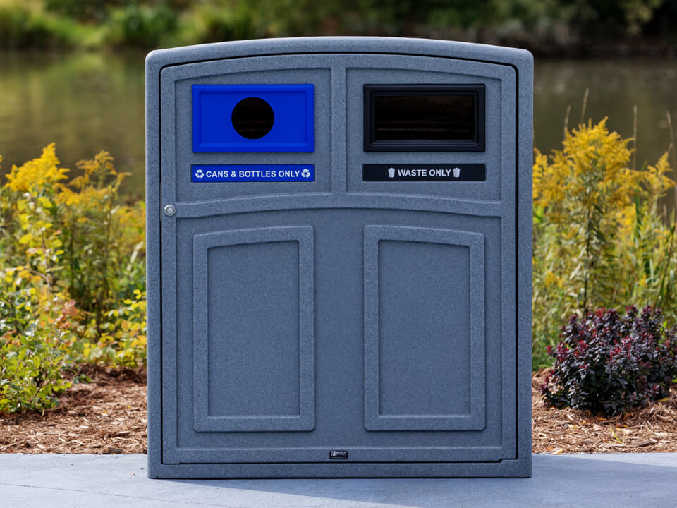 grey plastic waste and recycling container with lockable front door and color coded openings in a city park