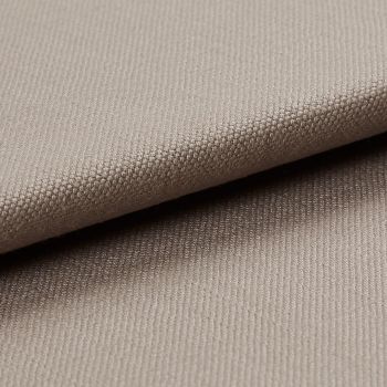 Beige tightly woven upholstery fabric, folded with an overlapping edge across the frame, revealing a pebble-like weave; close-up macro view with soft neutral lighting and plain background.