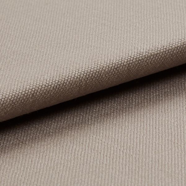 Beige tightly woven upholstery fabric, folded with an overlapping edge across the frame, revealing a pebble-like weave; close-up macro view with soft neutral lighting and plain background.