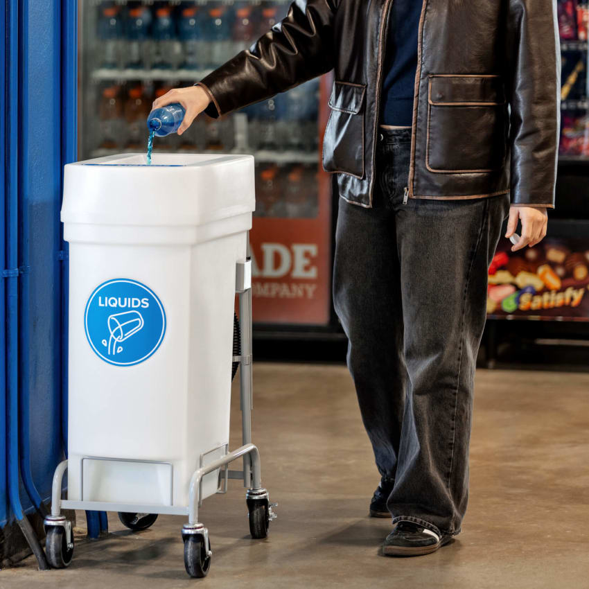 woman emptying bottle into liquid collection bin at a stadium