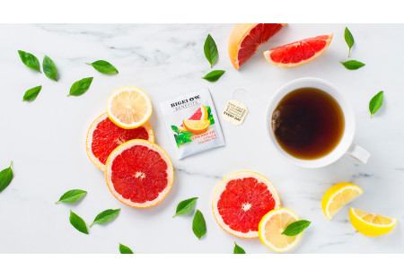 Lifestyle image of a cup of Lean and Fit Citrus and Oolong tea with tea bag and foil wrap