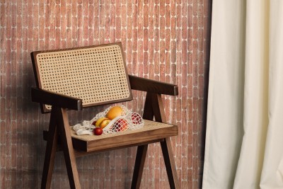 a rattan chair in front of a wooden wall.