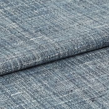 Blue-gray woven fabric swatch with irregular white flecks â€” folded and overlapped â€” close-up studio view with even lighting, emphasizing coarse looped weave and subtle color variation.