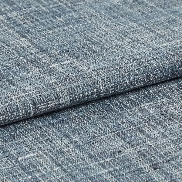 Blue-gray woven fabric swatch with irregular white flecks — folded and overlapped — close-up studio view with even lighting, emphasizing coarse looped weave and subtle color variation.