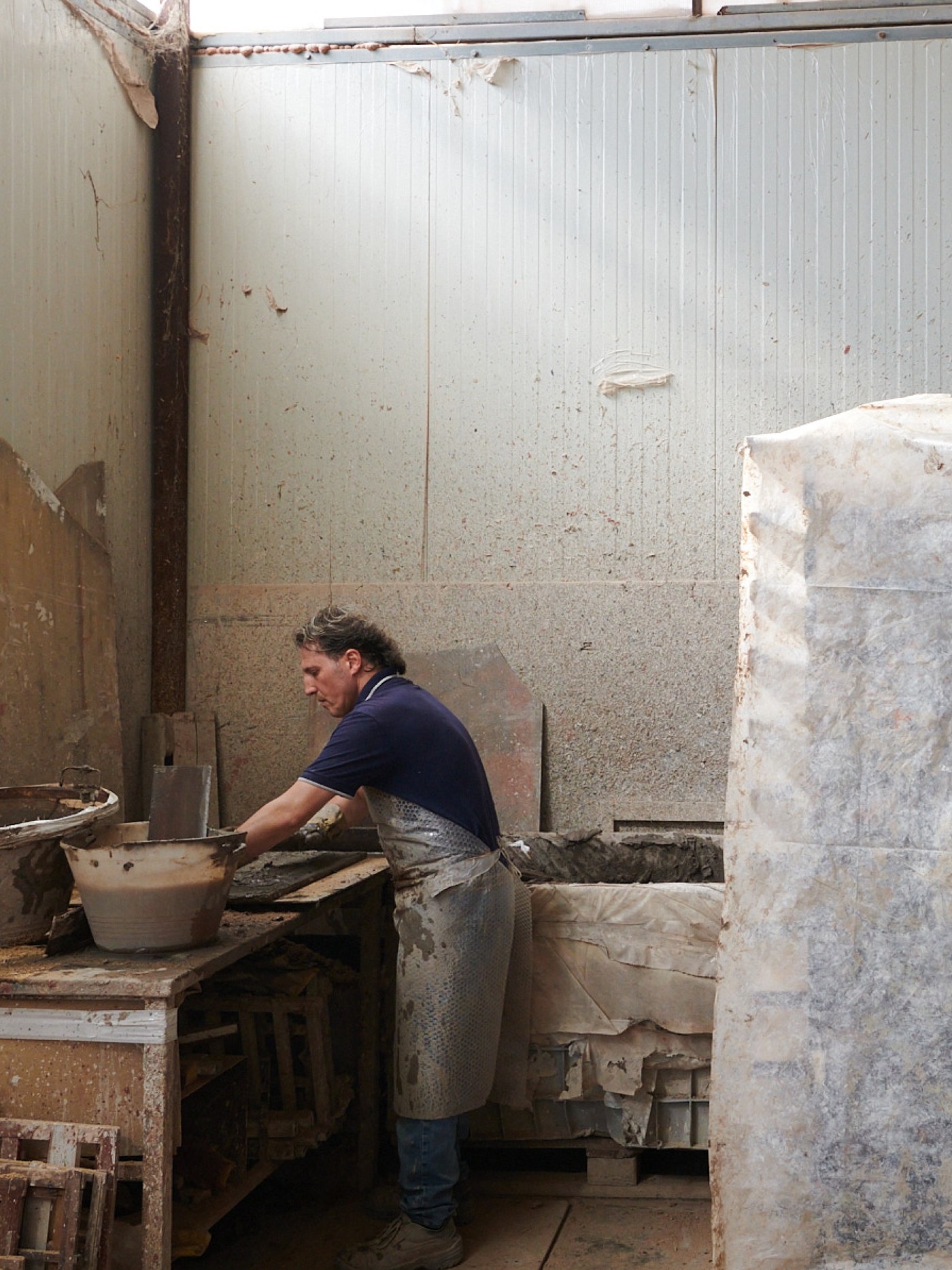 a man crafting tile in a studio.