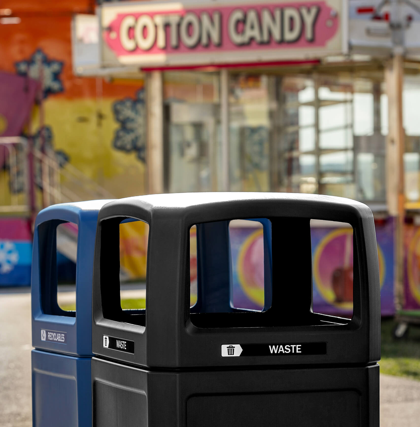 double recycling and trash station in front of outdoor midway with canopy lids