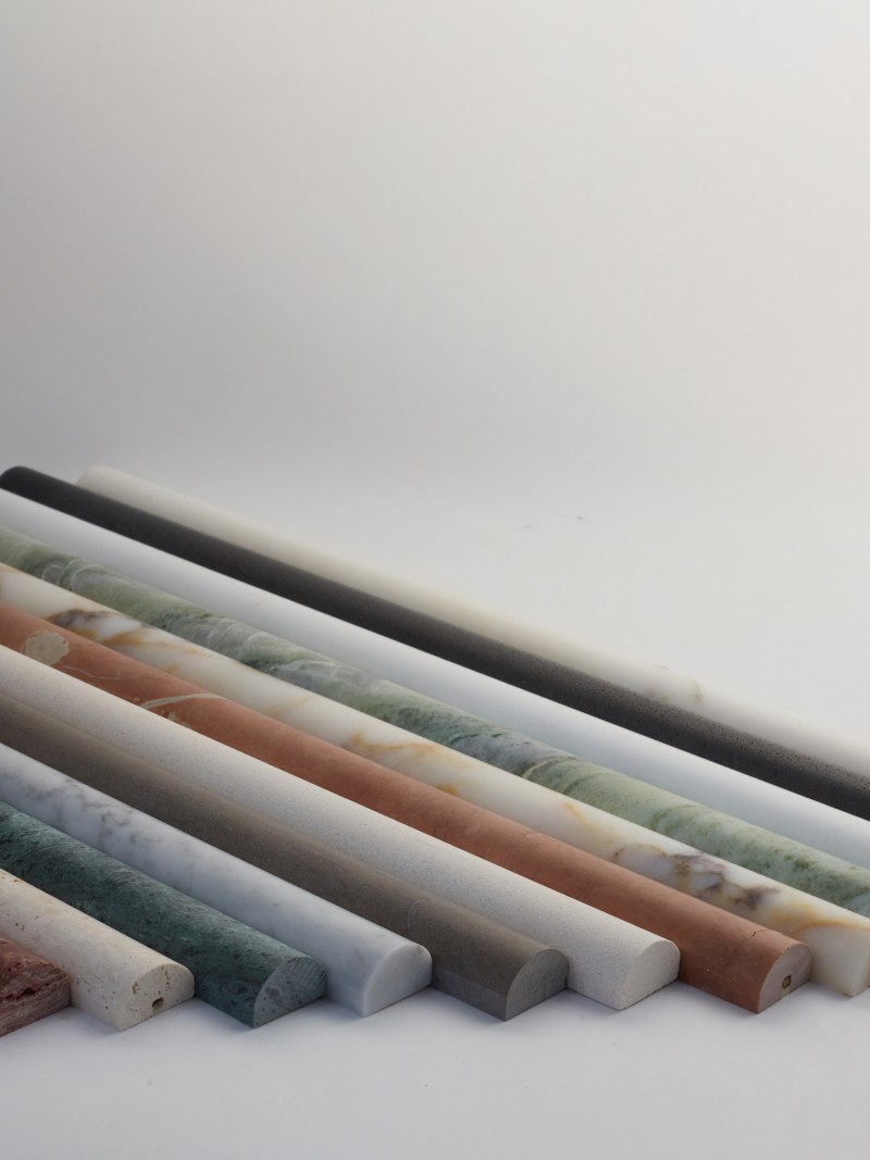 a row of different colored marbles on a white surface.