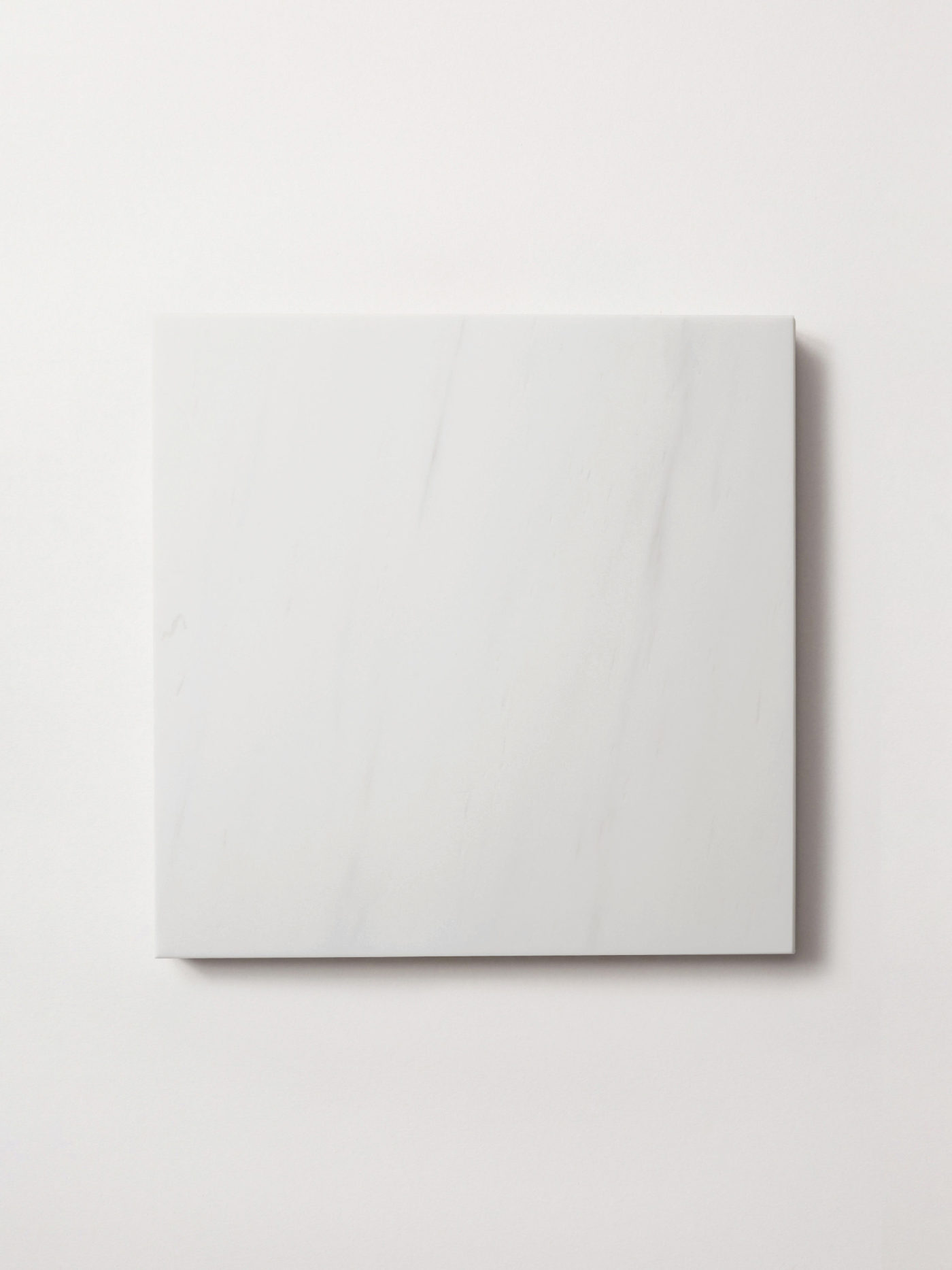 a white square tile on a white surface.